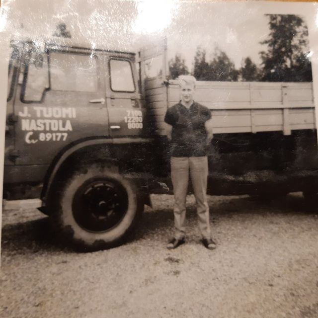 Vanha kuva miehestä kuljetusauton vieressä